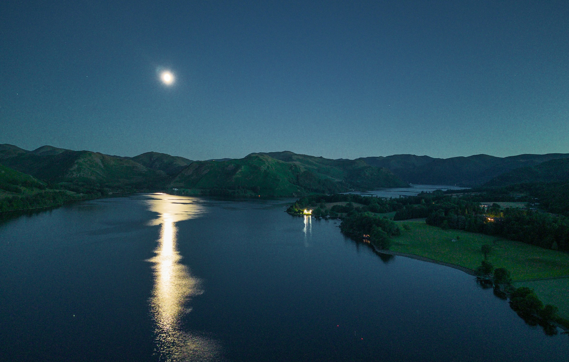 Moonlight reflected across Ullswater, with quiet fells on the horizon
